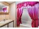 Bathroom features a vanity with a sink, floral wallpaper, and a shower/tub combination with a pink shower curtain at 5538 Antigua Dr, Zephyrhills, FL 33541