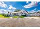 Charming clubhouse featuring golf carts, flagpole, and well-maintained landscaping under a sunny sky at 5538 Antigua Dr, Zephyrhills, FL 33541