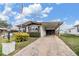Nice single-story home featuring a covered parking area, American flag, and manicured lawn at 5538 Antigua Dr, Zephyrhills, FL 33541