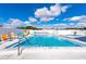 Community pool with clear blue water, lounge chairs, and a spacious deck at 5538 Antigua Dr, Zephyrhills, FL 33541