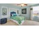 Cozy bedroom featuring stylish decor, comfortable bed, and a ceiling fan at 5636 Silver Moonlight Dr, Palmetto, FL 34221