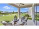 Relaxing covered patio with comfortable seating overlooking a serene pond and lush green lawn at 5636 Silver Moonlight Dr, Palmetto, FL 34221