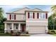 Two-story home featuring red shutters, a two-car garage, and a welcoming front porch at 5636 Silver Moonlight Dr, Palmetto, FL 34221