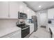 Well-equipped kitchen featuring white cabinets, stainless-steel appliances, and quartz countertops at 5970 Grand Sonata Ave, Lutz, FL 33558