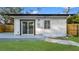 An exterior view of the home featuring a well-maintained lawn, stone paver walkway, and backyard patio at 6326 22Nd N Ave, St Petersburg, FL 33710