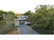 Exterior view of the home featuring a large driveway, a carport, and mature trees at 6326 22Nd N Ave, St Petersburg, FL 33710