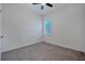 Bright bedroom with a ceiling fan, gray carpet, and a window with white shutters at 724 Winterside Dr, Apollo Beach, FL 33572