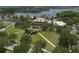 Aerial view of a community clubhouse, green lawn, palm trees, landscaping, sidewalks and parking spaces with a lake backdrop at 724 Winterside Dr, Apollo Beach, FL 33572