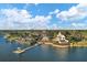 An aerial view highlights community amenities including docks, a pool, and a lakefront clubhouse under a sunny, cloudy sky at 724 Winterside Dr, Apollo Beach, FL 33572