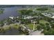 An aerial view displays a lakefront community clubhouse, pool, docks, and surrounding trees under a bright, cloudy sky at 724 Winterside Dr, Apollo Beach, FL 33572