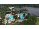 A full aerial view of the community pool, splash area, water slide, and lighthouse feature next to a picturesque lake at 724 Winterside Dr, Apollo Beach, FL 33572