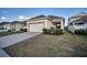 Well-maintained front exterior featuring lush landscaping, and an attached two car garage at 724 Winterside Dr, Apollo Beach, FL 33572