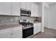 Close-up of kitchen features stainless steel stove, microwave, granite countertops, and stylish backsplash at 724 Winterside Dr, Apollo Beach, FL 33572