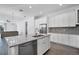 Kitchen island with dishwasher features white cabinets and sink, complementing the open-concept design at 724 Winterside Dr, Apollo Beach, FL 33572