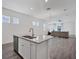 A large open area features a kitchen with an island that flows into a living space with large windows at 724 Winterside Dr, Apollo Beach, FL 33572