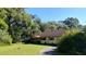 A well-maintained single-story home with mature trees and landscaping in a rural setting at 7608 Chenkin, Zephyrhills, FL 33540
