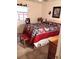 Main bedroom displays a red and blue quilt, with a window providing natural light at 7608 Chenkin, Zephyrhills, FL 33540