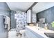 Modern bathroom featuring gray tile, a shower-tub combo with floral curtain, and a white vanity with large mirror at 8201 Cavalry Dr, Hudson, FL 34667