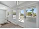 Bright hallway with views to a balcony and tropical landscaping through French doors at 901 Bay Esplanade, Clearwater Beach, FL 33767