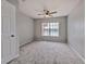 Carpeted bedroom featuring a ceiling fan and a bright window for natural light at 9204 Lake Chase Island Way # 9204, Tampa, FL 33626