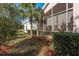 Lush backyard featuring a screened-in patio, mature trees, and well-maintained landscaping at 9233 Souchak Dr, Trinity, FL 34655
