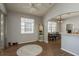 This living room has wood floors, a ceiling fan, and leads to the dining room at 9233 Souchak Dr, Trinity, FL 34655