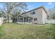 Expansive backyard showcasing the screened patio, sun room, and lush lawn at 9318 Heritage Oak Ct, Tampa, FL 33647