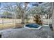 Outdoor screened-in patio area featuring a small hot tub, concrete patio, and backyard views at 9318 Heritage Oak Ct, Tampa, FL 33647