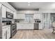 Bright kitchen with stainless steel appliances, white cabinets and light wood flooring at 9318 Heritage Oak Ct, Tampa, FL 33647