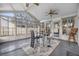 Bright sun room with vaulted ceiling, ceiling fan, a glass table set, and large windows at 9318 Heritage Oak Ct, Tampa, FL 33647