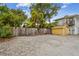 Rear gravel parking pad with adjacent yellow outbuilding at 1045 6Th N St, St Petersburg, FL 33701