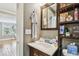 Bathroom with vanity, mirror, wooden shelving, and an open doorway to another room at 1045 6Th N St, St Petersburg, FL 33701