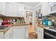 Cozy kitchen featuring white cabinets, granite countertops, and a view into an adjoining room at 1045 6Th N St, St Petersburg, FL 33701