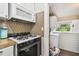 Compact kitchen area featuring a gas range, microwave, and connection to an adjacent laundry area at 1045 6Th N St, St Petersburg, FL 33701