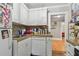 The quaint kitchen features white cabinetry, tile backsplash, and granite countertops at 1045 6Th N St, St Petersburg, FL 33701