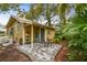 Charming yellow backyard cottage with brick patio and lush tropical landscaping at 1045 6Th N St, St Petersburg, FL 33701