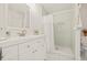 Bathroom features a shower with sage green tile and white vanity with gold hardware at 10925 124Th Ave, Largo, FL 33778