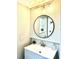 Updated bathroom with a stylish vanity, modern fixtures, and a round mirror reflecting natural light at 1101 Canal St, Ruskin, FL 33570