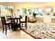 Sunroom dining area with tile flooring, rug, a table with four chairs, and a sun-lit sitting area at 1101 Canal St, Ruskin, FL 33570