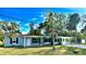 Exterior view featuring a sunroom, a well-kept lawn, and beautiful trees, providing curb appeal at 1101 Canal St, Ruskin, FL 33570