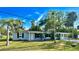 Exterior view showcasing a well-maintained lawn, mature trees, and classic architectural details at 1101 Canal St, Ruskin, FL 33570