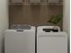 Laundry room featuring stacked washer and dryer, wire shelving, and earth-tone walls at 11251 E 65Th Ter, Palmetto, FL 34221