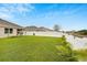 Enjoy the serene backyard with white fencing, green grass, and lush plants at 12018 Gillingham Harbor Ln, Gibsonton, FL 33534