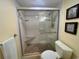 Updated bathroom showcasing glass enclosed shower with bench and mosaic tile details at 1353 Mission Cir, Clearwater, FL 33759