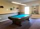 Bright game room featuring a well-maintained pool table with cue rack and ping pong paddles on wall at 1353 Mission Cir, Clearwater, FL 33759