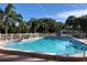 Community pool featuring sparkling water, lounge chairs, palm trees, and a white fence at 1353 Mission Cir, Clearwater, FL 33759