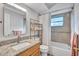 Bathroom featuring granite vanity top, tile floors, and a shower-tub combo with updated tile surround at 1487 Dundee Dr, Palm Harbor, FL 34684