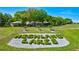 Well-maintained lawn featuring 'Highland Lakes' sign made of greenery and white rocks, surrounded by mature trees at 1487 Dundee Dr, Palm Harbor, FL 34684