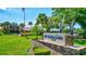 Landscaped community entrance with 'Highland Lakes Club' sign, palm trees, and a manicured lawn at 1487 Dundee Dr, Palm Harbor, FL 34684