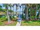 Pathway to a wooden dock on the lake, surrounded by lush trees and foliage at 1487 Dundee Dr, Palm Harbor, FL 34684